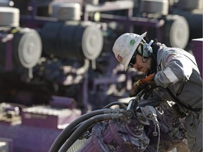 A worker oils a pump during a hydraulic fracturing operation at an Encana Corp. well pad in March 2014.