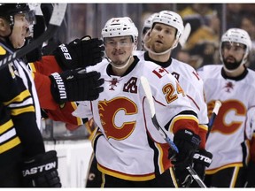 Calgary Flames left wing Jiri Hudler (24) is congratulated by teammates after his goal against the Boston Bruins during the second period of an NHL hockey game in Boston, Thursday, March 5, 2015.