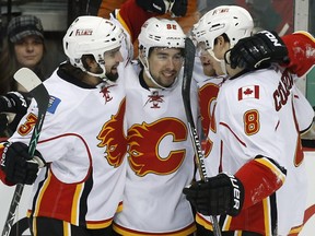 Calgary Flames' Josh Jooris, center, is congratulated by teammates after his goal off Minnesota Wild goalie Devan Dubnyk in the first period of an NHL hockey game, Friday, March 27, 2015, in St. Paul, Minn.