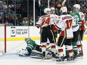 Dallas Stars goalie Kari Lehtonen looks back to see Calgary Flames' Jiri Hudler celebrating his goal with teammates Johnny Gaudreau and Sean Monahan in the second period on Monday. The Flames chased Lehtonen from the net in a 5-3 win.