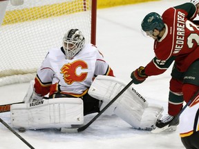 Calgary Flames goalie Karri Ramo, left, of Finland, stops a shot by Minnesota Wild's Nino Niederreiter, of Switzerland, in the first period of an NHL hockey game, Friday, March 27, 2015, in St. Paul, Minn.