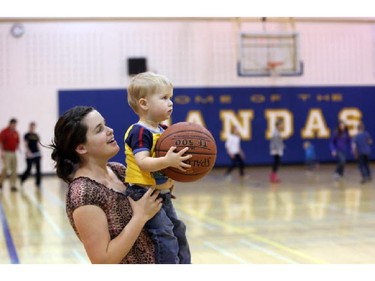 Sean Fyfe, 1, and his mom Indie Fyfe shoot some hoops in halftime during the Junior Varsity Pandas versus the Junior Varsity Rebels in the Southern Alberta town of Magrath, on March 13, 2015.