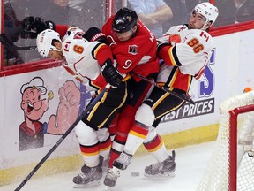 Ottawa Senators forward Milan Michalek is checked by Calgary Flames' Denis Wideman, left, and Josh Jooris during the first period on Sunday.