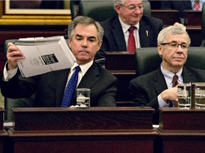 Alberta Premier Jim Prentice, left, grabs the budget after Alberta Finance Minister Robin Campbell,right, delivered the 2015 budget in Edmonton, Alta., on Thursday, March 26, 2015.