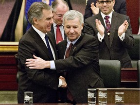 Alberta Premier Jim Prentice, left, shakes hands Alberta with Finance Minister Robin Campbell after he delivered the 2015 budget in Edmonton on March 26, 2015.