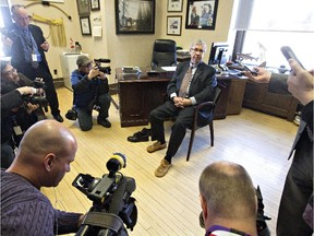 Alberta Finance Minister Robin Campbell tries on a new pair of moccasins during a pre-budget photo opportunity in Edmonton on March 24, 2015.