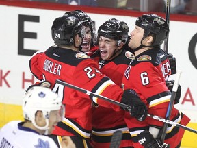 Members of the Calgary Flames, from left, centre Jiri Hudler, centre Sean Monahan, left winger Johnny Gaudreau and defenceman Dennis Wideman celebrated after Gaudreau scored against the Toronto Maple Leafs during first period NHL action at the Scotiabank Saddledome on March 13, 2015.