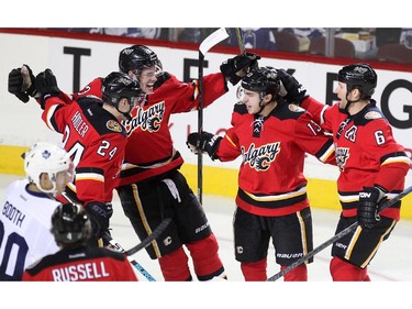 Members of the Calgary Flames, from left, centre Jiri Hudler, centre Sean Monahan, left winger Johnny Gaudreau and defenceman Dennis Wideman celebrated after Gaudreau scored against the Toronto Maple Leafs during first period NHL action at the Scotiabank Saddledome on March 13, 2015.