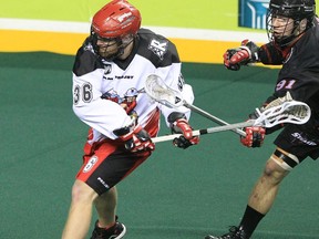 The Calgary Roughnecks' Daryl Veltman, left, is hassled by the Vancouver Stealth's Tyler Garrison during their NLL game at the Scotiabank Saddledome in Calgary Saturday, February 15, 2014.