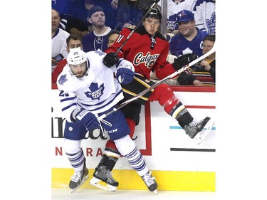 Calgary Flames centre Mikael Backlund was driven into the boards by Toronto Maple Leafs defenceman TJ Brennan during second period NHL action at the Scotiabank Saddledome on March 13, 2015.