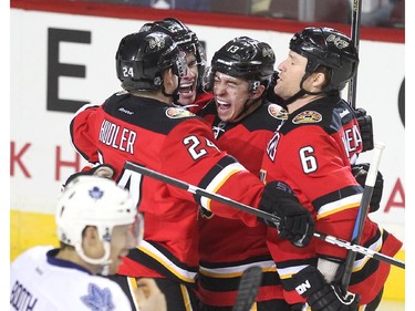Members of the Calgary Flames, from left, centre Jiri Hudler, centre Sean Monahan, left winger Johnny Gaudreau and defenceman Dennis Wideman celebrated after Gaudreau scored against the Toronto Maple Leafs during first period NHL action at the Scotiabank Saddledome on March 13, 2015.