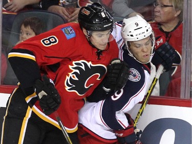 Calgary Flames centre Joe Colborne drove Columbus Blue Jackets left winger Jeremy Morin into the boards during first period NHL action at the Scotiabank Saddledome on March 21, 2015.