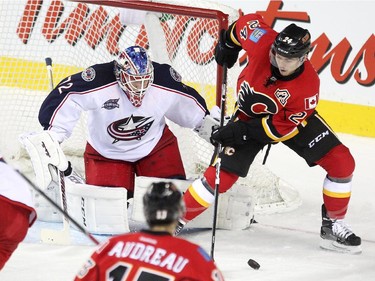 Calgary Flames centre Jiri Hudler handled the puck just outside the net of Columbus Blue Jackets goalie Sergei Bobrovsky during first period NHL action at the Scotiabank Saddledome on March 21, 2015.
