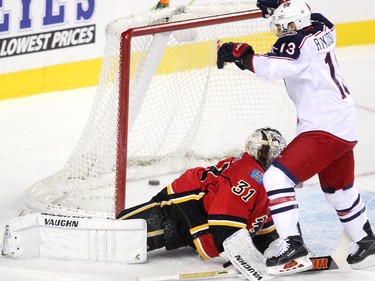 Calgary Flames goalie Karri Ramo looked at the puck in the net as Columbus Blue Jackets right winger Cam Atkinson celebrated outside the crease during first period NHL action at the Scotiabank Saddledome on March 21, 2015.