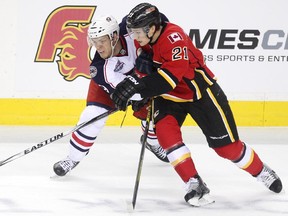 Calgary Flames left winger Mason Raymond leans into Columbus Blue Jackets left winger Jeremy Morin during Saturday's meeting at the Scotiabank Saddledome.