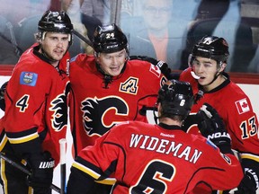 Calgary Flames rookie Johnny Gaudreau, right, seen helping Kris Russell left, Jiri Hudler and Dennis Wideman celebrate Hudler's first-period goal against the Colorado Avalanche on Monday night, grew up idolizing Daniel Briere. Now the Avs veteran is the one wowed by Gaudreau.