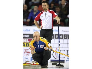 Alberta skip Kevin Koe called to his front end as Newfoundland Labrador skip Brad Gushue watched from behind during the afternoon draw at the Tim Hortons Brier at the Scotiabank Saddledome in Calgary on March 4, 2015.