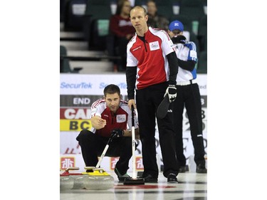 Team Canada's John Morris, left, talked strategy with skip Pat Simmons during their game against B.C.'s Jim Cotter  during the Wednesday morning draw of the Tim Horton's Brier at the Scotiabank Saddledome on March 4, 2015. Team Canada scored 2 on the final shot of the game to defeat B.C. 8-7.