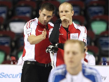 Team Canada's John Morris, left, talked strategy with skip Pat Simmons during their game against B.C.'s Jim Cotter  during the Wednesday morning draw of the Tim Horton's Brier at the Scotiabank Saddledome on March 4, 2015. Team Canada scored 2 on the final shot of the game to defeat B.C. 8-7.