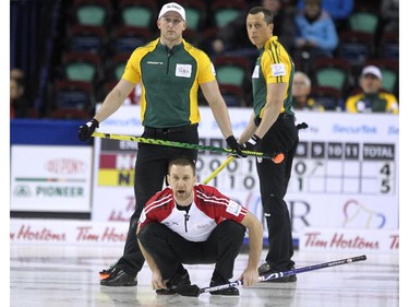 Newfoundland Labrador skip Brad Gushue, foreground, kept an eye on his shot as Northern Ontario front end Ryan Harnden, left, and E.J. Harnden watched from behind during the morning draw of the Tim Hortons Brier at the Scotiabank Saddledome in Calgary on March 5, 2015. Newfoundland Labrador won the game 6-5 handing Northern Ontario its first loss of the Brier.