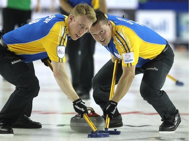 Alberta third Marc Kennedy, left, and lead Ben Hebert carried a shot down the ice against Saskatchewan during the afternoon draw at the Tim Hortons Brier at the Scotiabank Saddledome in Calgary on March 5, 2015.