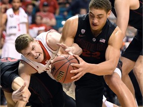 Dallin Bachynski of the Utah Utes battles Reid Travis of the Stanford Cardinal during a quarterfinal game of the Pac-12 Basketball Tournament on March 12 in Las Vegas. Utah won 80-56.