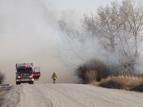 Members of the fire department attend to the scene of a grass fire near Chestermere in April 2012.