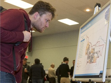 Ben (last name withheld), reads an information board detailing Calgary's wards while at a open house for secondary suites at Killarney community hall in Calgary, on March 1, 2015.