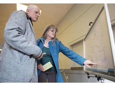 Brad, left, and Alison Lait read an information board detailing Calgary's wards while at a open house for secondary suites at Killarney community hall in Calgary, on March 1, 2015.