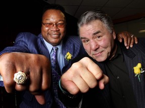 Canadian boxing legend George Chuvalo, right, seen with the great Larry Holmes at the 2011 Italian sports dinner in Calgary, is back in the area for the White Collar Boxing event at Flames Central on Thursday.