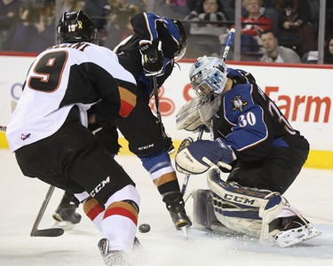 Calgary Hitman left winger Radel Fazleev, left, swoops in on a busy net at the Scotiabank Saddledome in Calgary on Friday, April 3, 2015. The Calgary Hitmen tied the Kootenay Ice, 1-1, at the first period in Game 4 of the Western Hockey League first-round playoff series.