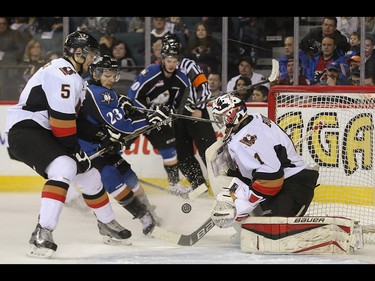 Kootenay Ice centre Sam Reinhart, centre, scores on Calgary Hitmen goalie Brendan Burke at the Scotiabank Saddledome in Calgary on Friday, April 3, 2015. The Calgary Hitmen tied the Kootenay Ice, 4-4, at the second period in Game 4 of the Western Hockey League first-round playoff series.