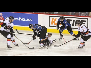 Calgary Hitman Pavel Padakin, centre, is forced to the ice by Kootenay Ice right winger Austin Vetterl at the Scotiabank Saddledome in Calgary on Friday, April 3, 2015. The Calgary Hitmen lost to the Kootenay Ice, 5-4, in Game 4 of the Western Hockey League first-round playoff series.