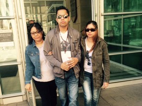 Erwin Manzano with sisters Emmylou Nolasco, left, and Elmalyn Lagman at Calgary Courts Centre after  Wilson Clorina, 28, was sentenced to 2 life terms with no chance of parole for 35 years for fatally stabbing Erwin's wife Chona, 35, and son Gabrial, 5, on May 16, 2013.