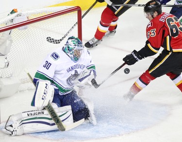 Vancouver Canucks netminder Ryan Miller, left, blocks a shot on net from Calgary Flames Sam Bennett during game 6 of the NHL Playoffs.