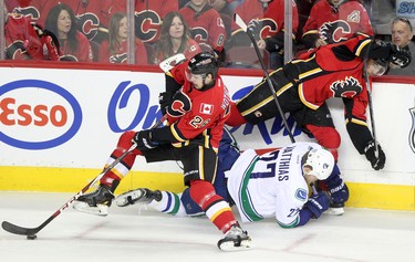 CALGARY.;  APRIL 25, 2015  -- Vancouver Canucks Shawn Matthias, middle, is checked into the boards by Calgary Flames Tyler Wotherspoon, left and David Jones during game 6 of the NHL Playoffs.