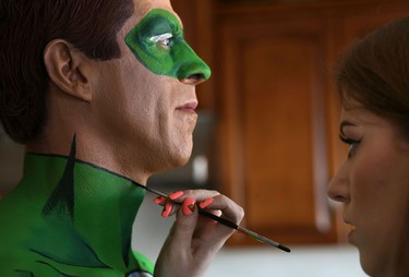 Makeup artist Lianne Moseley paints model Ken Dove into DC Comic character Green Lantern at her home in Calgary.