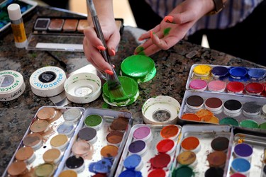 Makeup artist Lianne Moseley paints model Ken Dove into DC Comic character Green Lantern at her home in Calgary.