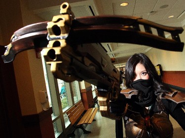 Diana Peng raises her bow at the Calgary Comic and Entertainment Expo Thursday April 16, 2015 just as the gates were opening. Decked out as Demon Hunter from the video game Diablo she had just passed the prop weapons checkpoint, a new requirement at this year's festival.