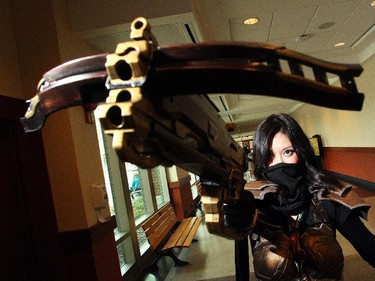 Diana Peng raises her bow at the Calgary Comic and Entertainment Expo Thursday April 16, 2015 just as the gates were opening. Decked out as Demon Hunter from the video game Diablo she had just passed the prop weapons checkpoint, a new requirement at this year's festival.