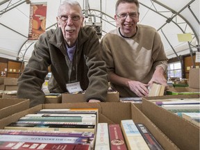 Father and son volunteers, Peter, left, and Richard Bottomley, take a break during the set up of the 13th annual Calgary Book Drive and Sale at Crossroads Market in Calgary, on April 23, 2015. The book sale kick starts on May 7 at 3 p.m.