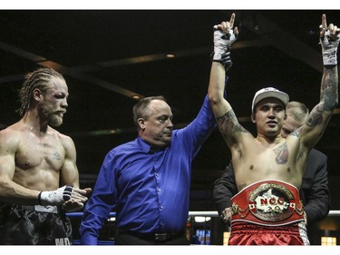 Steve 'The Dragon' Claggett, right, receives the championship belt after beating 'Mighty' Tebor Brosch's during the main event of the Canadian Championship Title Fight welterweight division at the Teofista boxing series 15 in Calgary, on April 3, 2015.