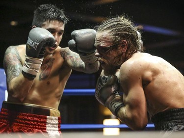 Steve 'The Dragon' Claggett, left, makes contact with 'Mighty' Tebor Brosch's face during the main event Canadian Championship Title Fight welterweight division at the Teofista boxing series 15 in Calgary, on April 3, 2015. Claggett successfully defended his championship title.