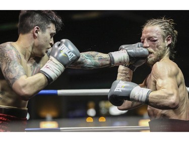 Steve 'The Dragon' Claggett, left, gives the 'Mighty' Tebor Brosch a mighty left jab during the main event Canadian Championship Title Fight welterweight division at the Teofista boxing series 15 in Calgary, on April 3, 2015. Claggett successfully defended his championship title.