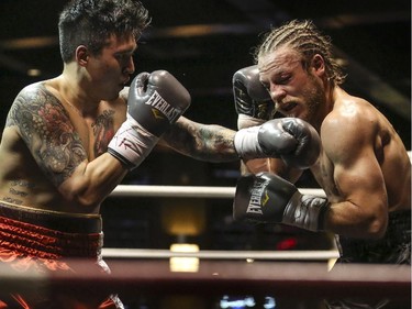 Steve 'The Dragon' Claggett, left, gives 'Mighty' Tebor Brosch at good left hook during the main event Canadian Championship Title Fight welterweight division at the Teofista boxing series 15 in Calgary, on April 3, 2015. Claggett successfully defended his championship title.