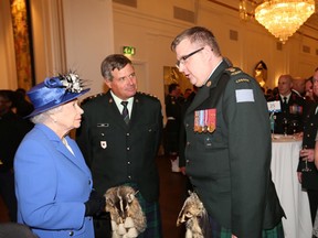 Major Peter Boyle, organizer of the 2015 battlefield pilgrimage, chats with the Queen at Canada House while Honorary Colonel Michael Shaw looks on.