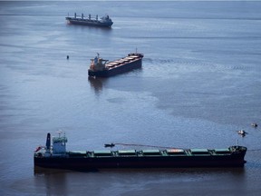 Spill response boats work to contain bunker fuel leaking from the bulk carrier cargo ship Marathassa.