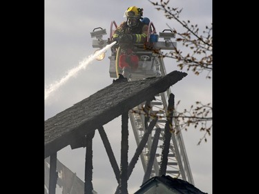 Firefighters extinguish a large fire on Hidden Valley Drive N.W. A home owner shows the emotion of seeing her home damaged by flames in a large fire on Hidden Valley Drive on April 20.