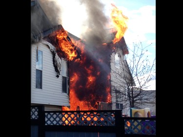 Neighbour Jaron Whelan shot this photo moments after a large large fire erupted on Hidden Valley Drive N.W. A home owner shows the emotion of seeing her home damaged by flames in a large fire on Hidden Valley Drive on April 20.
Photo Courtesy Jaron Whelan