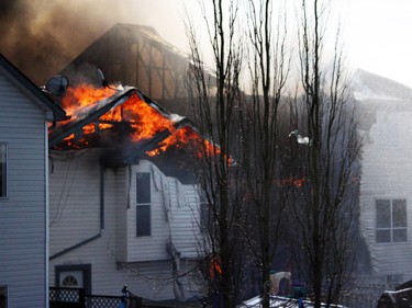 Neighbour Jaron Whelan shot this photo moments after a large large fire erupted on Hidden Valley Drive N.W. A home owner shows the emotion of seeing her home damaged by flames in a large fire on Hidden Valley Drive on April 20.